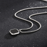 Men's black onyx square pendant necklace flat lay stainless steel chain