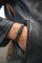 Men's braided leather bracelet front view on wrist engraved stainless steel clasp