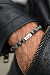 Men's lava stone bracelet with personalised engraved plate worn on wrist