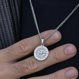 Men's silver North Star pendant necklace held in hand stainless steel