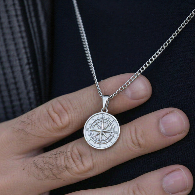 Men's silver North Star pendant necklace held in hand stainless steel