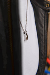 Men's personalised bar necklace worn on model dark background silve