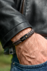 Men's personalised medical alert bracelet worn on wrist with leather jacket braided leather
