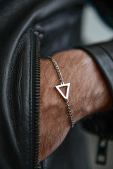 Close up of triangle charm detail on men's silver stainless steel bracelet