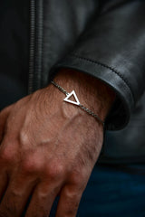 Men's silver triangle bracelet worn on wrist with leather jacket stainless steel